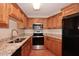Traditional kitchen with granite countertops, stainless steel appliances, and wood cabinetry at 8625 E Belleview Pl # 1012, Scottsdale, AZ 85257