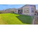 Expansive backyard with lush lawn, covered patio, and neutral-toned home exterior at 9734 E Spiral Ave, Mesa, AZ 85212