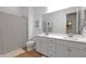 Bright bathroom with double sinks, a large mirror, and a shower with a curtain at 9734 E Spiral Ave, Mesa, AZ 85212