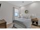 Cozy bedroom featuring a comfortable bed, neutral tones, and ample natural light from the window at 9734 E Spiral Ave, Mesa, AZ 85212