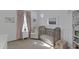 Charming Bedroom features a crib, armchair, soft lighting, and window with pink curtains at 9734 E Spiral Ave, Mesa, AZ 85212