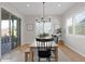 Bright dining area with a wooden table, modern chandelier, and large sliding glass door at 9734 E Spiral Ave, Mesa, AZ 85212