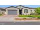 Charming single-story home with gray stucco, complemented by a well-manicured lawn, and a two car garage at 9734 E Spiral Ave, Mesa, AZ 85212