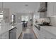An open kitchen features sleek white cabinetry, a large island, and a dining area nearby at 9734 E Spiral Ave, Mesa, AZ 85212