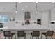 Kitchen island with seating and pendant lights, with stainless steel appliances and white cabinets at 9734 E Spiral Ave, Mesa, AZ 85212