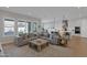 Open-concept living area with large windows, featuring a modern gray sofa and a kitchen island at 9734 E Spiral Ave, Mesa, AZ 85212