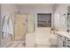 Bright bathroom features a soaking tub, stand-up shower and neutral wall paint and fixtures at 9758 E Monterey Ave, Mesa, AZ 85209