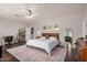 A bright bedroom with a ceiling fan, desk, shelving, and decorative rug at 9758 E Monterey Ave, Mesa, AZ 85209
