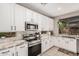 Bright kitchen with white cabinets, granite counters, stainless appliances, and tiled backsplash at 9758 E Monterey Ave, Mesa, AZ 85209