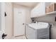 Bright laundry room featuring white cabinets and modern washer and dryer units at 9758 E Monterey Ave, Mesa, AZ 85209