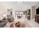 Open concept living area leads to a bright kitchen with white cabinets and updated appliances at 9758 E Monterey Ave, Mesa, AZ 85209