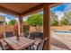 Covered outdoor patio with dining table, seating, grill, and view of the pool at 9758 E Monterey Ave, Mesa, AZ 85209