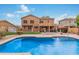 Stunning backyard showcasing a refreshing blue pool, green grass, and a covered patio perfect for outdoor entertaining at 9758 E Monterey Ave, Mesa, AZ 85209