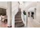 Inviting foyer showcasing a curved staircase with white railings and neutral carpeting at 9758 E Monterey Ave, Mesa, AZ 85209