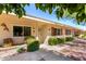 Cozy one-story home boasts beautiful desert landscaping, light-colored siding, and bright awnings at 10547 W Coggins Dr, Sun City, AZ 85351
