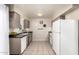 Well-lit kitchen with tile flooring, white appliances, neutral cabinets, and stylish wall decor at 10547 W Coggins Dr, Sun City, AZ 85351