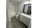 Bathroom features a tub and shower, a white vanity, and wood-look tile flooring at 1132 E 9Th Pl, Casa Grande, AZ 85122