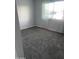 Neutrally painted bedroom with a large window that lets in light and plush carpeting throughout at 1132 E 9Th Pl, Casa Grande, AZ 85122