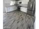 A bright kitchen features white cabinets, stainless steel appliances, and light gray wood-look tile floors at 1132 E 9Th Pl, Casa Grande, AZ 85122