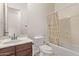 This bathroom features a vanity with dark wood cabinets, toilet, and shower with printed shower curtain at 12910 W Tuckey Ln, Glendale, AZ 85307