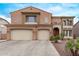 Beautiful two-story home featuring a three car garage and a red front door entrance at 12910 W Tuckey Ln, Glendale, AZ 85307