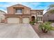 Beautiful two-story home featuring a three car garage and a red front door entrance at 12910 W Tuckey Ln, Glendale, AZ 85307