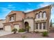 Beautiful two-story home featuring a three car garage and a red front door entrance at 12910 W Tuckey Ln, Glendale, AZ 85307