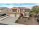 Stunning two-story home featuring a red-tile roof, dual garages and pristine desert landscaping at 12910 W Tuckey Ln, Glendale, AZ 85307