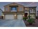 Elegant two-story home featuring a three-car garage, beautifully landscaped front yard and a red front door at 12910 W Tuckey Ln, Glendale, AZ 85307