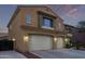 Two-story home features a two-car garage and desert landscaping creating an inviting curb appeal at 12910 W Tuckey Ln, Glendale, AZ 85307