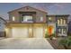 Two-story home features a three-car garage, beautifully landscaped front yard and an orange front door at 12910 W Tuckey Ln, Glendale, AZ 85307