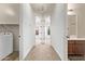 Bright hallway with beige carpet leading to bedrooms, laundry, and bathroom at 12910 W Tuckey Ln, Glendale, AZ 85307