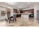 Inviting kitchen features an island, dark wood cabinets, stainless appliances, and dining area at 12910 W Tuckey Ln, Glendale, AZ 85307