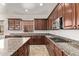 Open kitchen featuring dark wood cabinets, granite countertops, and stainless steel microwave at 12910 W Tuckey Ln, Glendale, AZ 85307