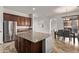 Kitchen with a central island, stainless steel fridge, and seamless flow into dining area at 12910 W Tuckey Ln, Glendale, AZ 85307