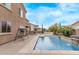 Beautiful backyard pool with custom water features, patio, and pergola under a bright blue sky at 12910 W Tuckey Ln, Glendale, AZ 85307