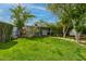 Large backyard with grass, shady trees, fencing, and a tranquil outdoor seating area at 1326 E Almeria Rd, Phoenix, AZ 85006