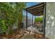 Covered patio area with stone flooring, wooden beams, an outdoor kitchen, and lush landscaping at 1326 E Almeria Rd, Phoenix, AZ 85006