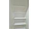 Walk-in closet with a series of three white shelves for tidy and efficient organization at 15422 S Sequoia Cir, Arizona City, AZ 85123