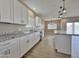 Bright kitchen with white cabinets, stainless appliances, granite counters, and island open to living area at 15422 S Sequoia Cir, Arizona City, AZ 85123