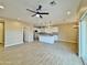Open-concept living space with modern ceiling fan, flowing into a bright kitchen and outdoor access at 15422 S Sequoia Cir, Arizona City, AZ 85123