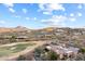 Expansive aerial shot showcases a stunning luxury estate nestled within a desert community, bordered by a lush golf course at 15956 E Tombstone Trl, Fountain Hills, AZ 85268