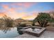 Backyard featuring a spa, desert landscaping, golf course views, and picturesque sunset at 15956 E Tombstone Trl, Fountain Hills, AZ 85268