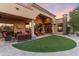 Expansive backyard featuring a covered patio, lush artificial turf, and desert landscaping creating a serene outdoor retreat at 15956 E Tombstone Trl, Fountain Hills, AZ 85268