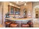 Stylish wet bar featuring granite countertops, custom cabinetry, and seating for four at 15956 E Tombstone Trl, Fountain Hills, AZ 85268
