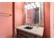 Bathroom vanity with a marble countertop, decorative mirror, and elegant lighting at 15956 E Tombstone Trl, Fountain Hills, AZ 85268
