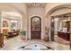 Open-concept home foyer featuring a large arched entryway, dark wood door, and tile flooring at 15956 E Tombstone Trl, Fountain Hills, AZ 85268