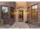 Elegant home entryway with stone accents, an arched doorway, and desert landscaping at 15956 E Tombstone Trl, Fountain Hills, AZ 85268