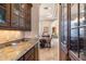 Hallway leading to the dining area, with hardwood cabinetry, granite counters, and a stone floor at 15956 E Tombstone Trl, Fountain Hills, AZ 85268