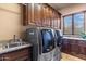 Well-equipped laundry room with front-loading washer/dryer and custom cabinetry at 15956 E Tombstone Trl, Fountain Hills, AZ 85268